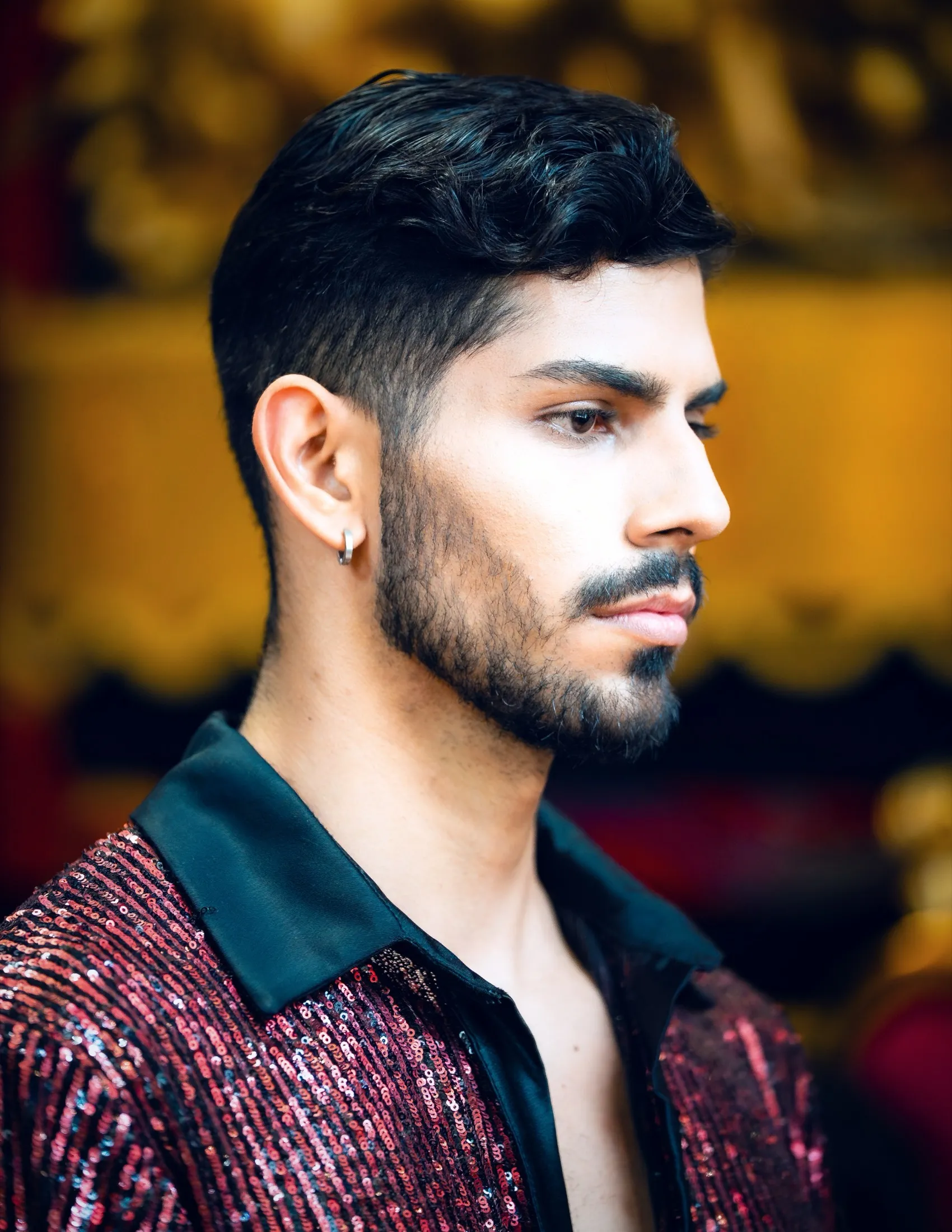 Modelo de perfil con camisa de lentejuelas roja y cuello negro en backstage de pasarela — Lookbook por Libraphotos